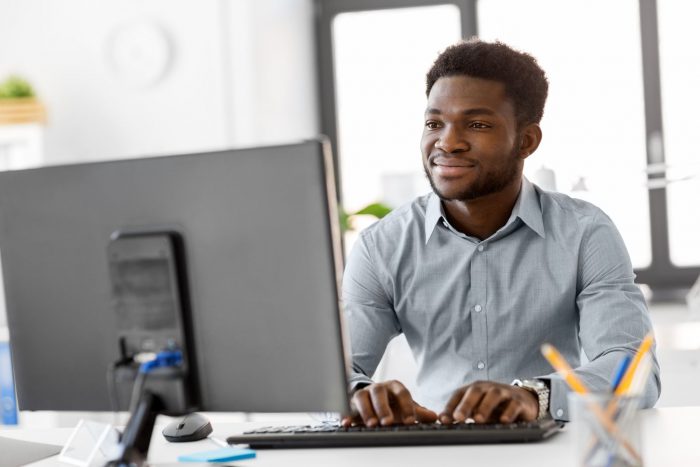 perfil-do-administrador - homem negro diante de computador digitando 