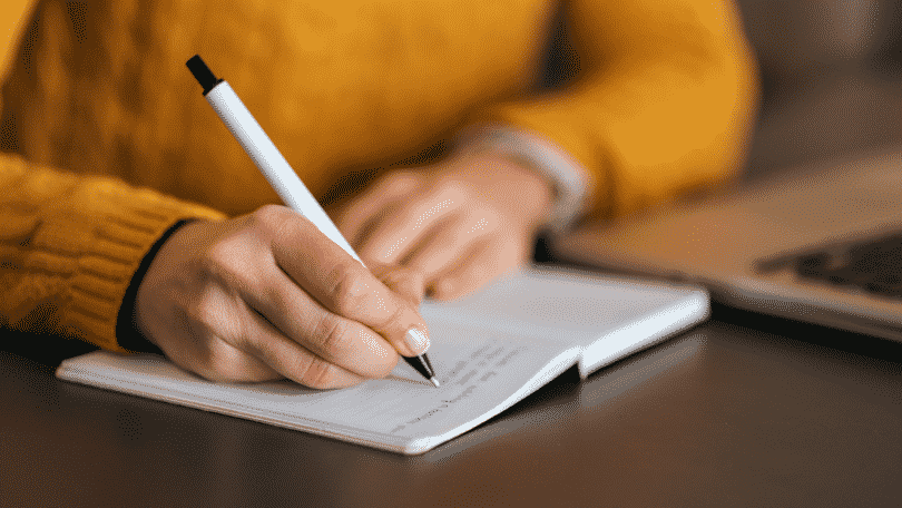 regra-do-hifen - pessoa escrevendo em caderno